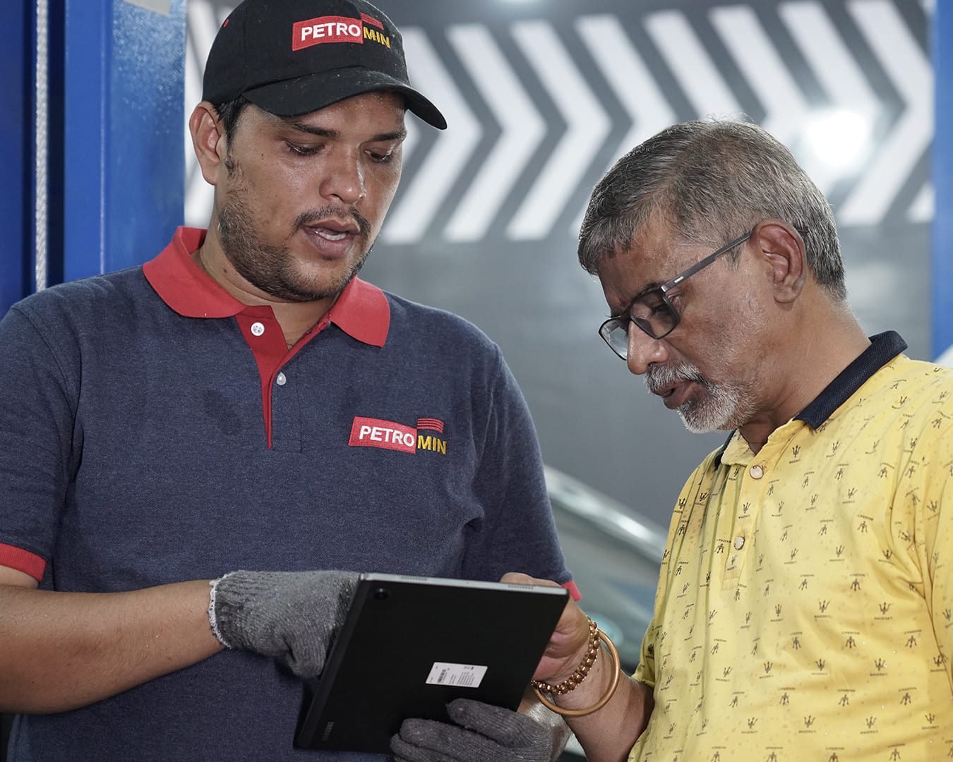 A Petromin Express explaining their analysis of a vehicle to a customer.